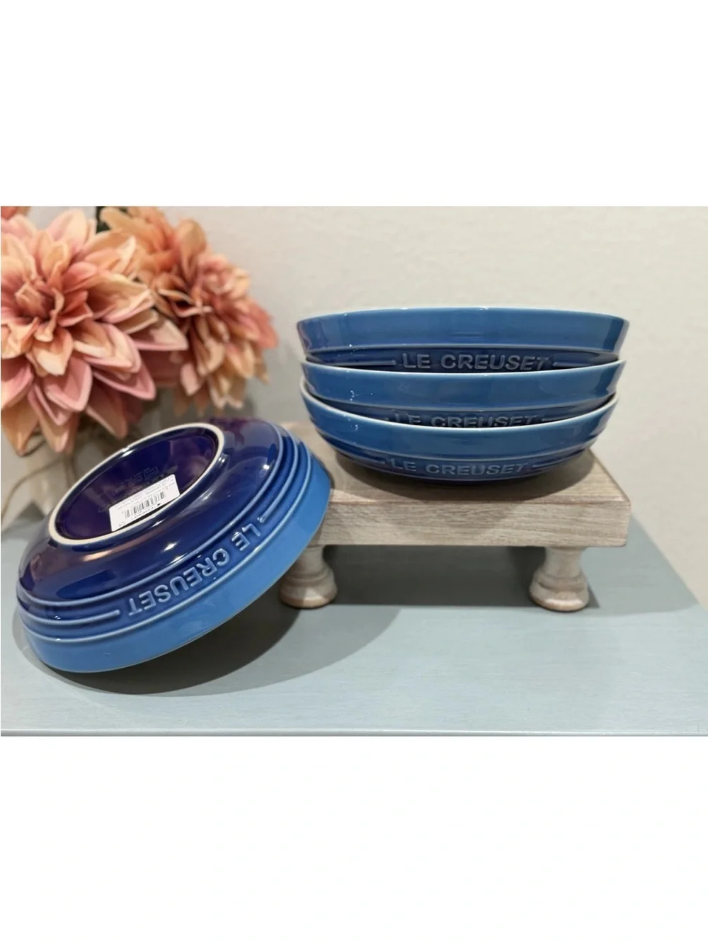 The product is a set of 4 Le Creuset deep round dish plates in a striking azure
